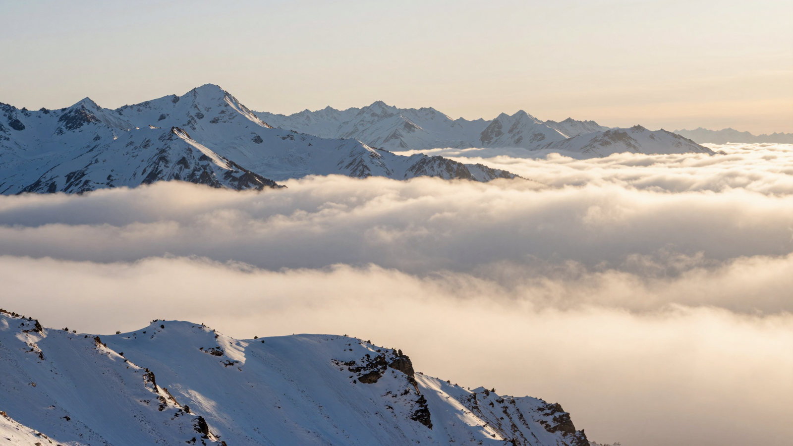 Snowy Mountain Peaks Rising Above a Sea of Clouds