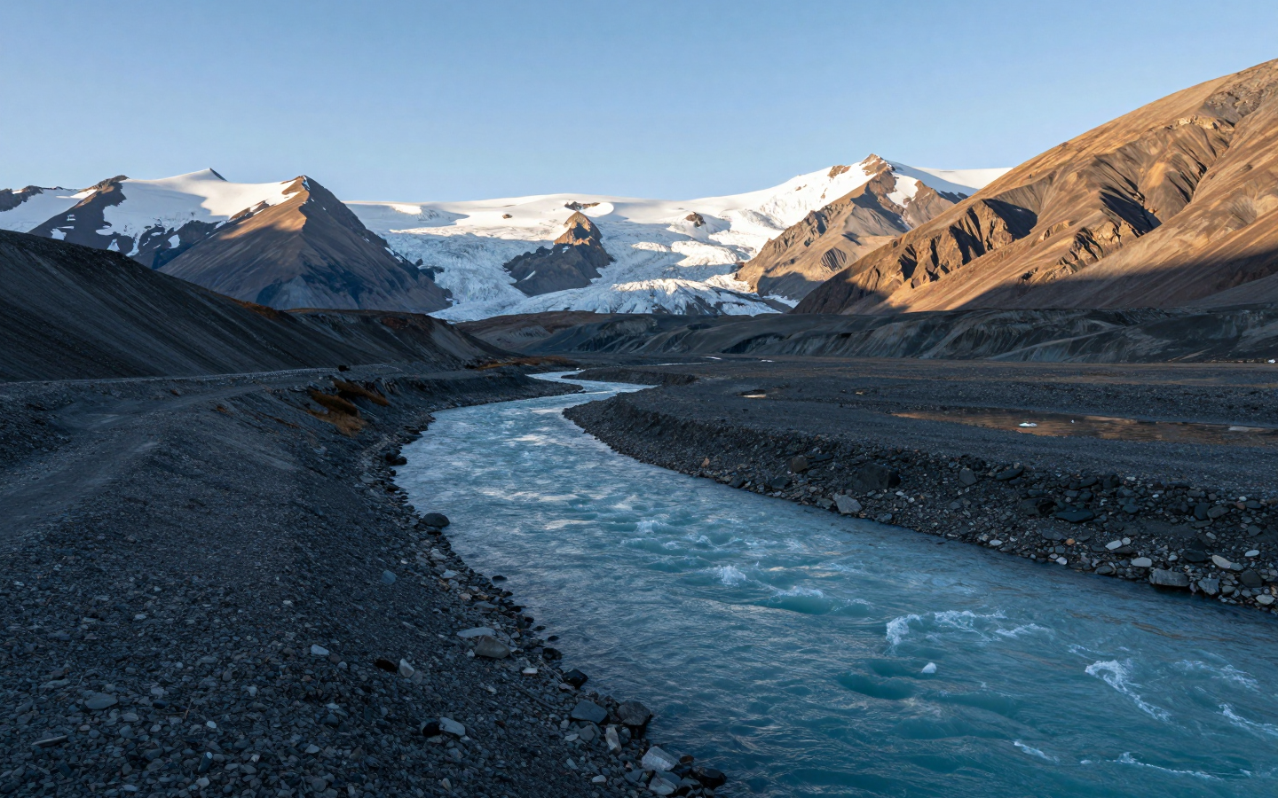 Turquoise Glacial River Flowing Through Snowy Mountain Valley