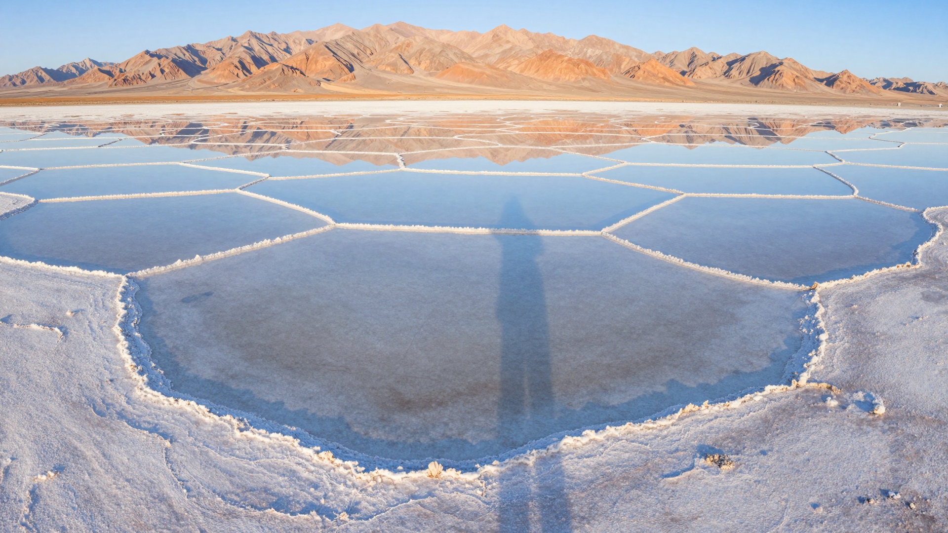 Geometric Salt Ponds Beneath Rugged Desert Mountains